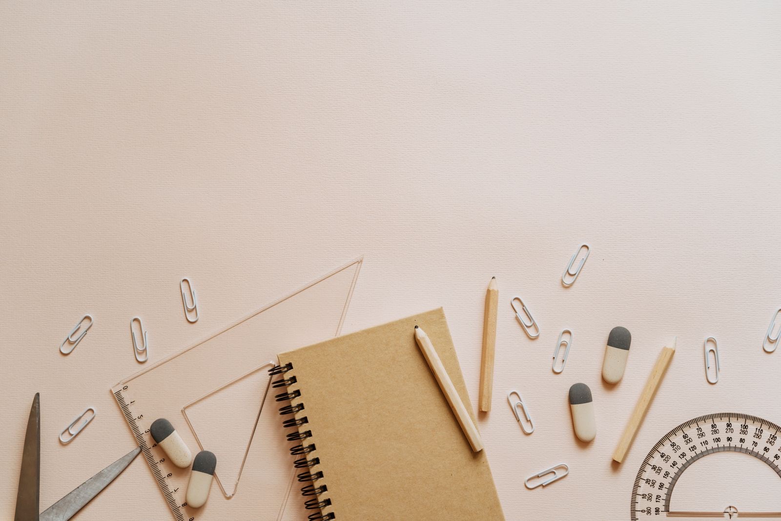 Notebook, pencils, and drawing tools laid out on a desk